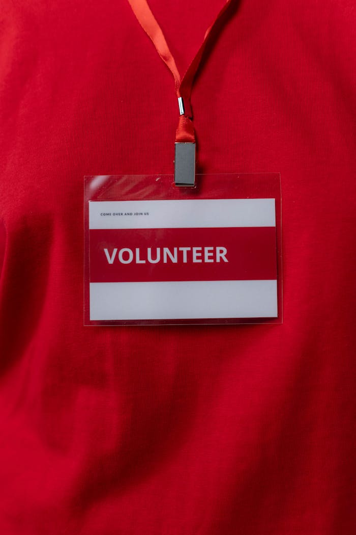 portfolio-02 A close-up of a volunteer name tag hanging on a red lanyard, symbolizing community service.