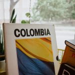 Vertical shot of a book with the Colombian flag displayed on its cover, indoors by a window.